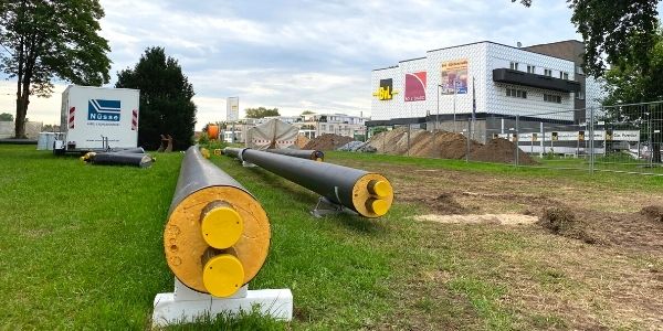 Baustelle mit großen Rohren und Geräten, Vorbereitungen für Infrastrukturarbeiten.