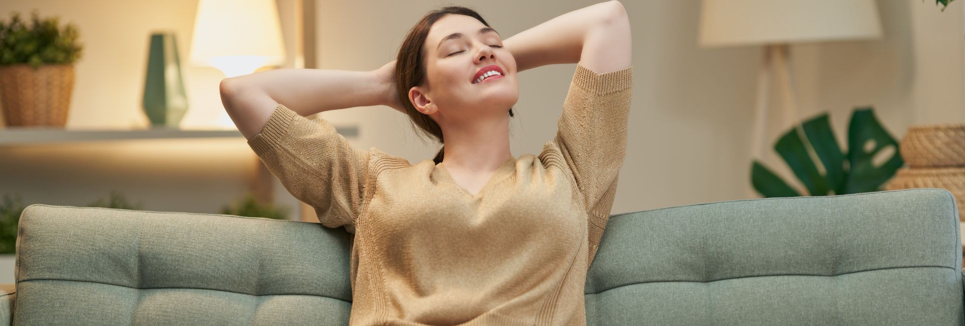 Frau sitzt entspannt auf einem Sofa
