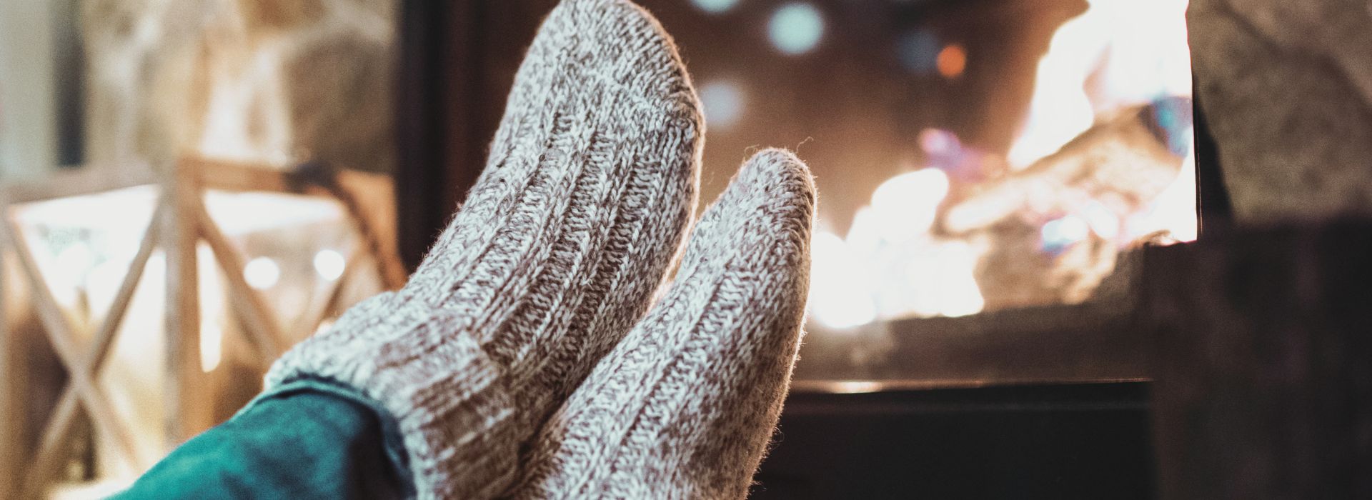 Füsse mit Socken wärmen sich vor dem Kaminfeuer