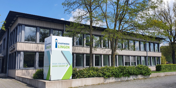 Bürogebäude der Stadtwerke Lingen mit Logo und Bäumen im Vordergrund.