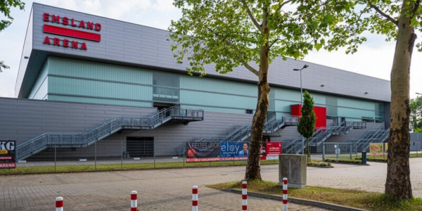 Außenansicht der EmslandArena in Lingen mit Bäumen im Vordergrund.