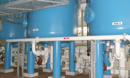 Große blaue Tanks mit Rohren und Ventilen im Wasserwerk