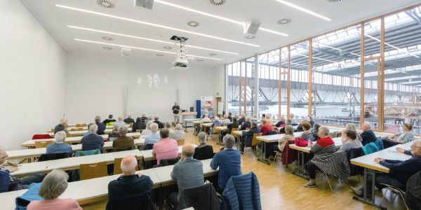 Bildquelle: Hochschule Osnabrück Viele Menschen sitzen an Tischen, die in Reihen aufgestellt sind