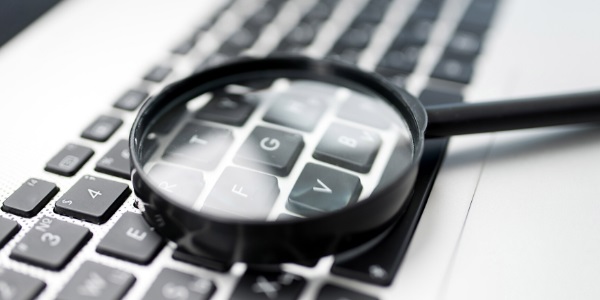 ein Vergrößerungsglas liegt auf einer Tastatur