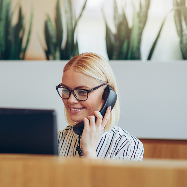 Frau hinter PC am Telefon