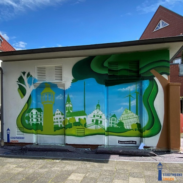 Bunte Wandmalerei an einem Gebäude in einer Stadt mit blauen Himmel.