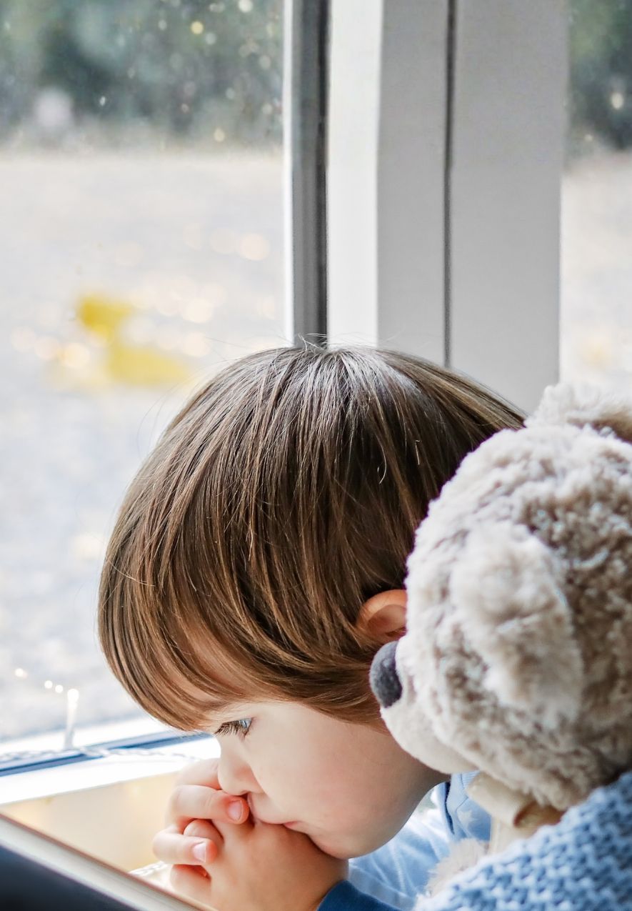 Junge kuschelt in Decke und liest ein Buch